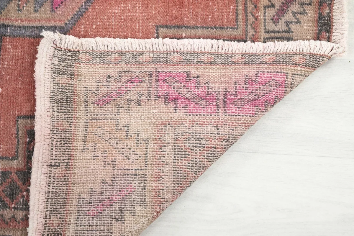 Detailed view of the low pile and the texture of the hand-knotted wool, showing natural wear