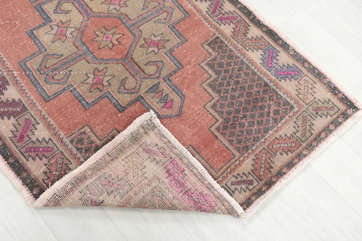 Corner of the rug folded back to reveal the hand-knotted wool pile and cotton foundation