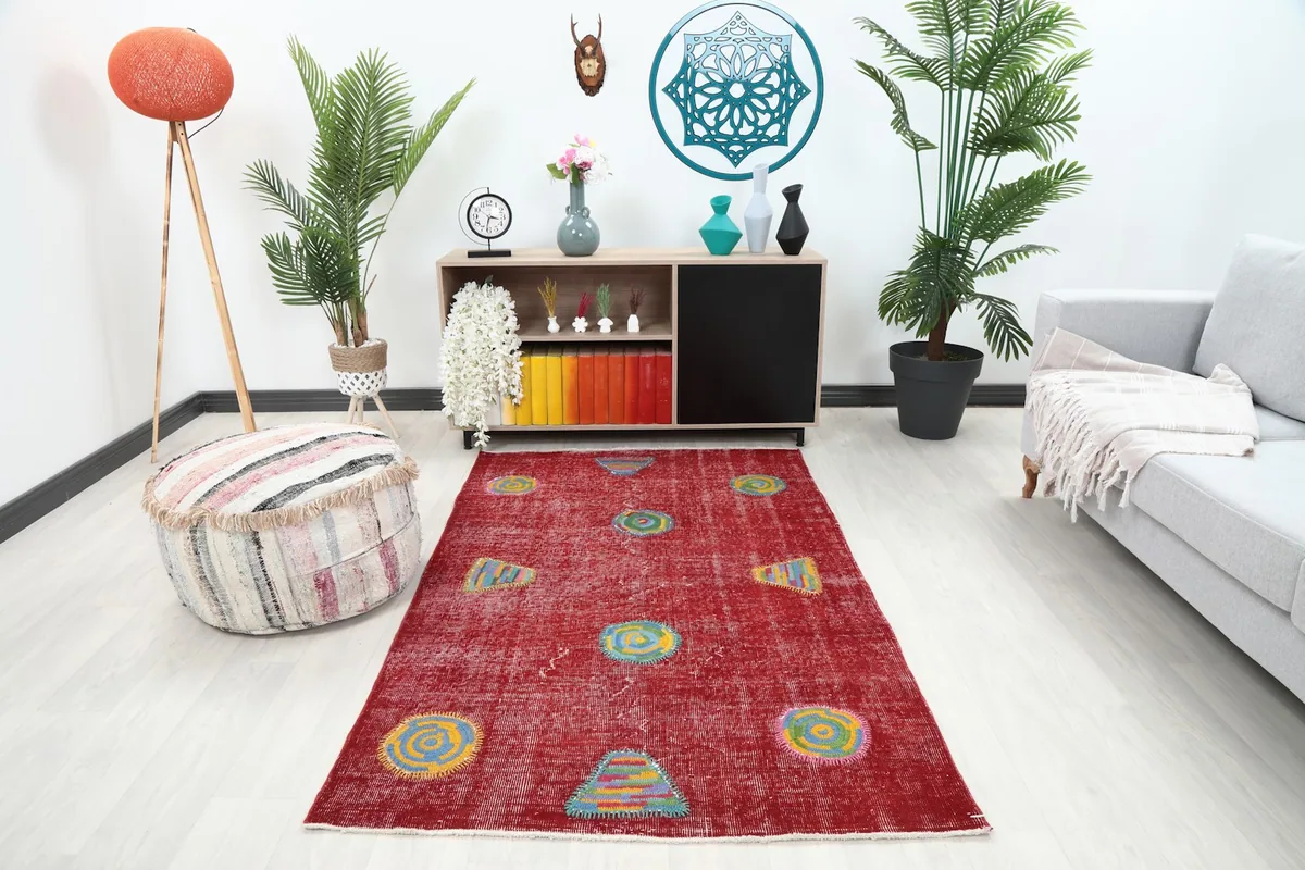 Vintage red geometric patchwork rug displayed in a bright living room setting with a light sofa