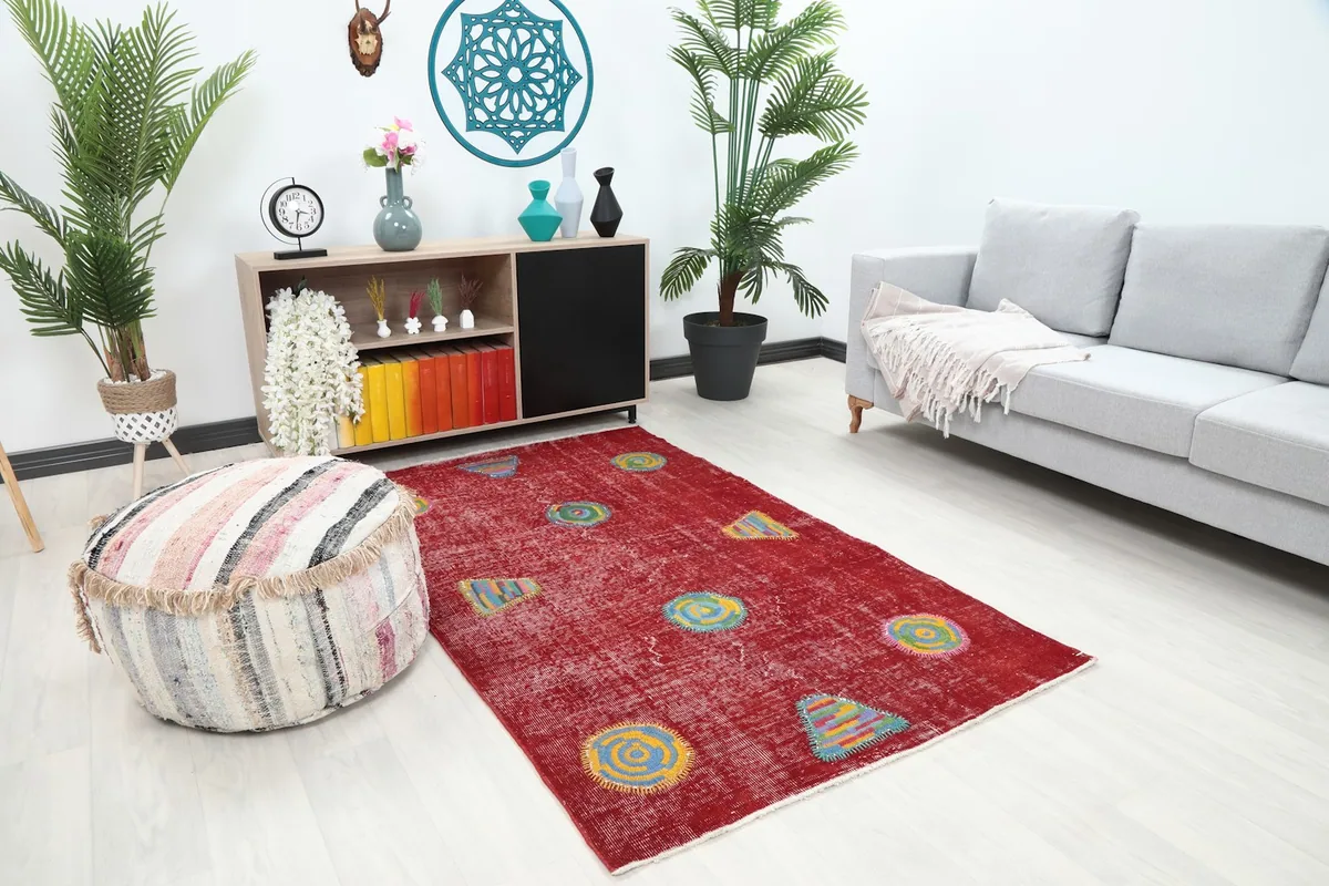 Angled view of the red vintage Anatolian rug in a living space, showing its size relative to furniture