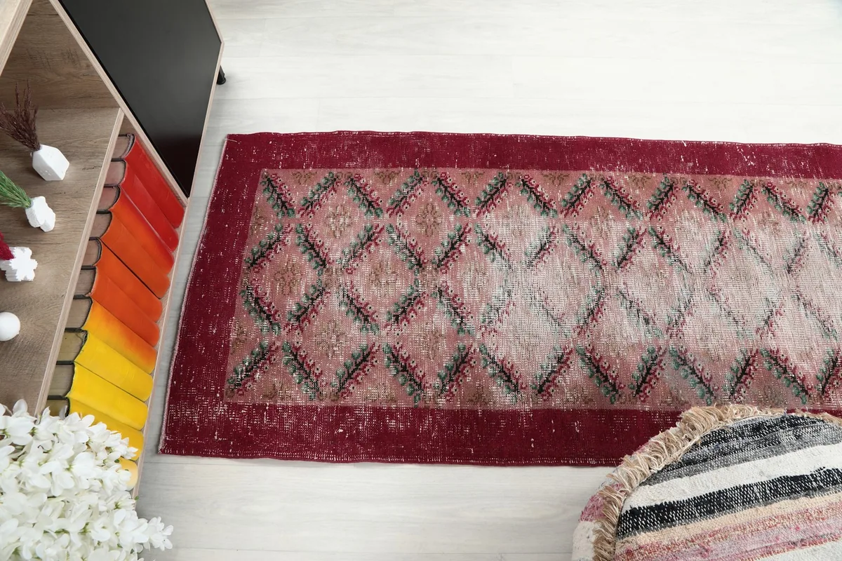 Side angle view of the runner rug, showing its length and the aged appearance of the wool