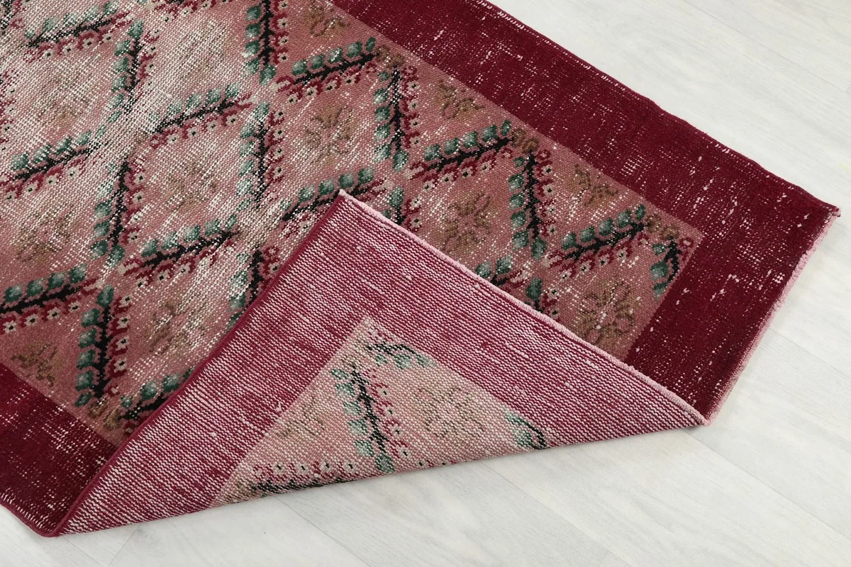 Corner of the rug folded back to reveal the back of the hand-knotted wool pile