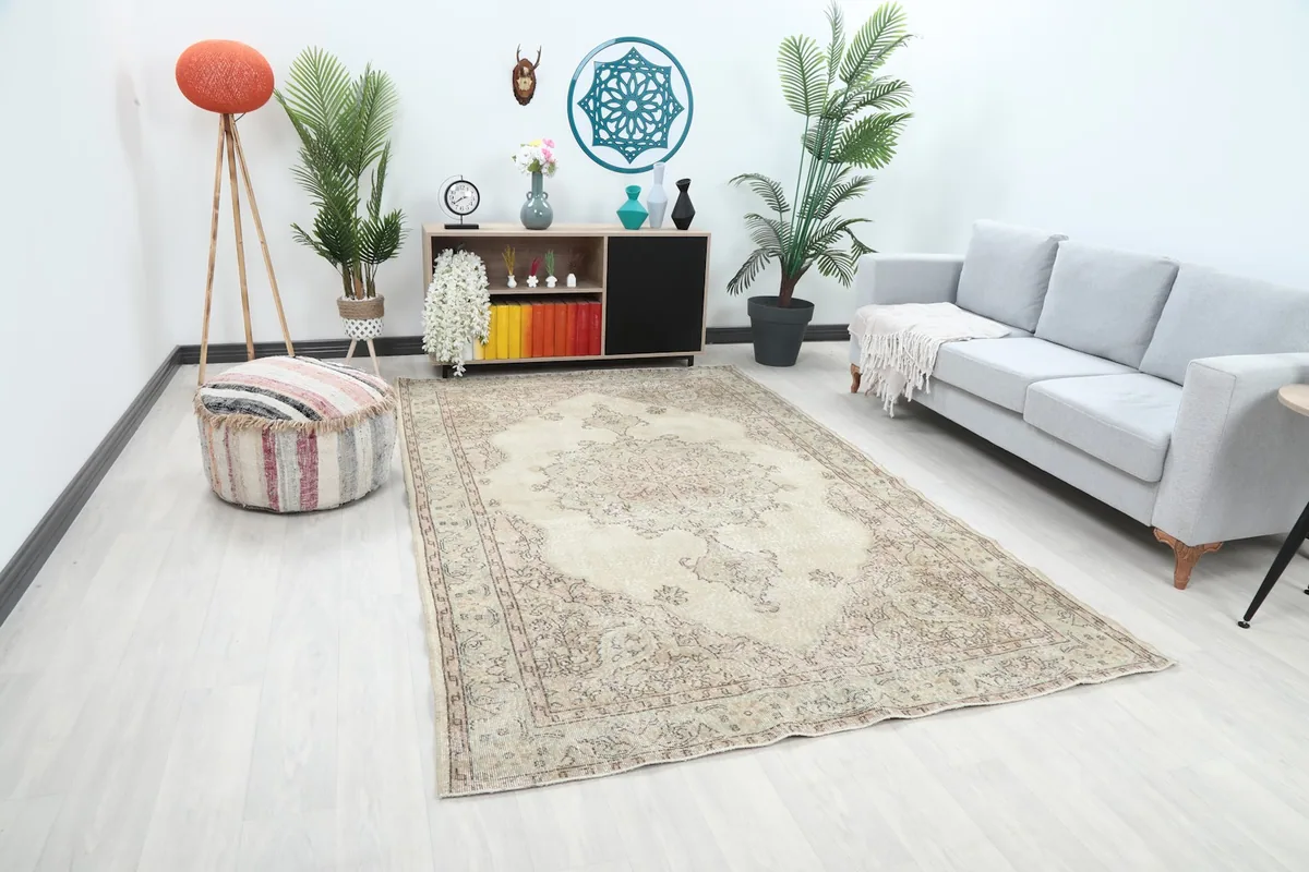 Angled view of the ivory and rose vintage rug in a living room, showcasing its blend with decor