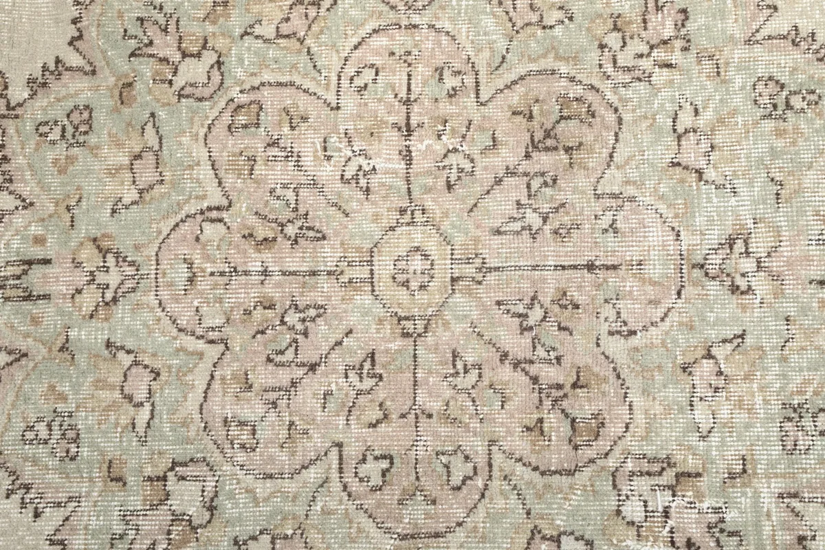 Close-up of the medallion's center, highlighting the delicate rose and green color variations in the wool pile