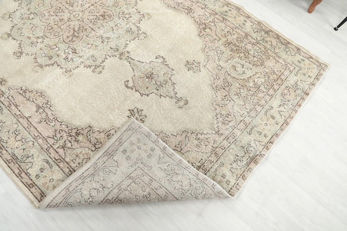 Corner of the rug folded back to reveal the back of the hand-knotted cotton foundation