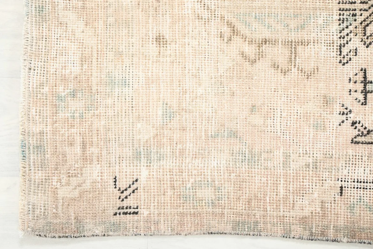 Close-up of the low wool pile and subtle color variations in the vintage rug
