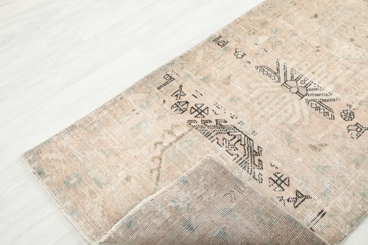View of a corner of the runner rug folded back, showing the back and front details