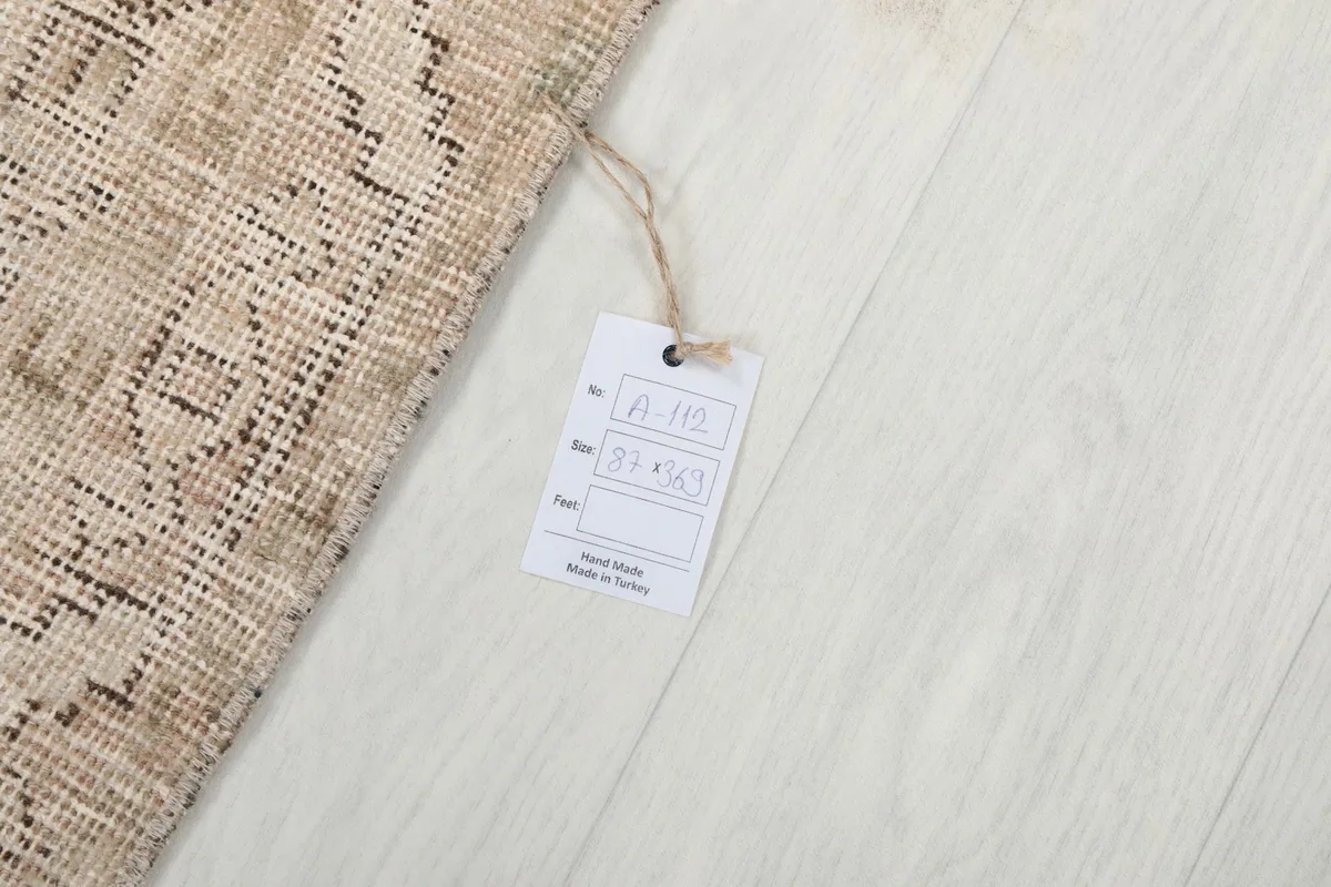 Product tag displaying size and origin, next to a corner of the runner rug