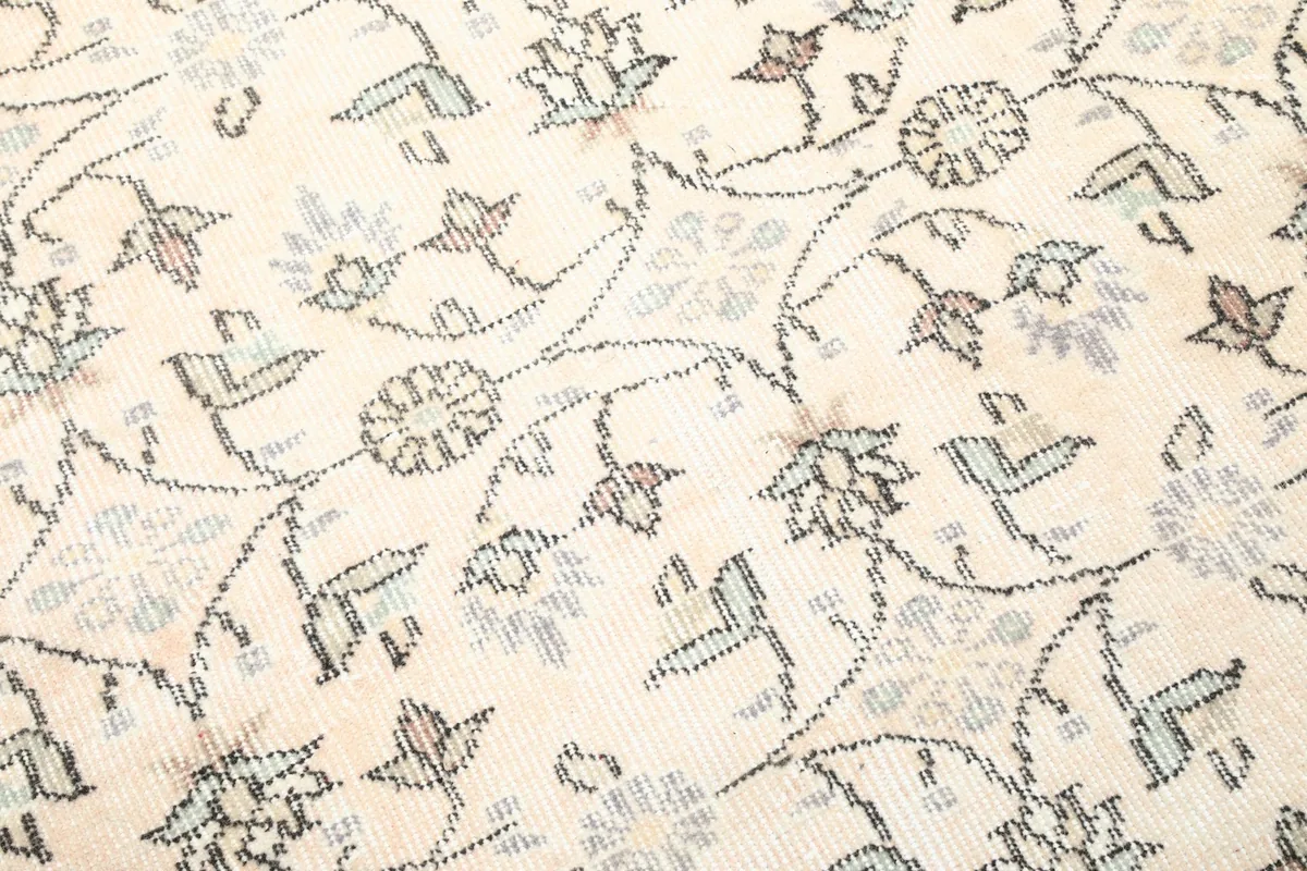 Close-up of the hand-knotted floral motifs and subtle color variations in the wool pile.