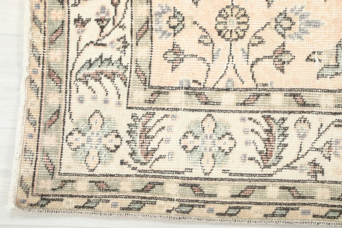 Corner detail showing the intricate floral and geometric border design of the rug.