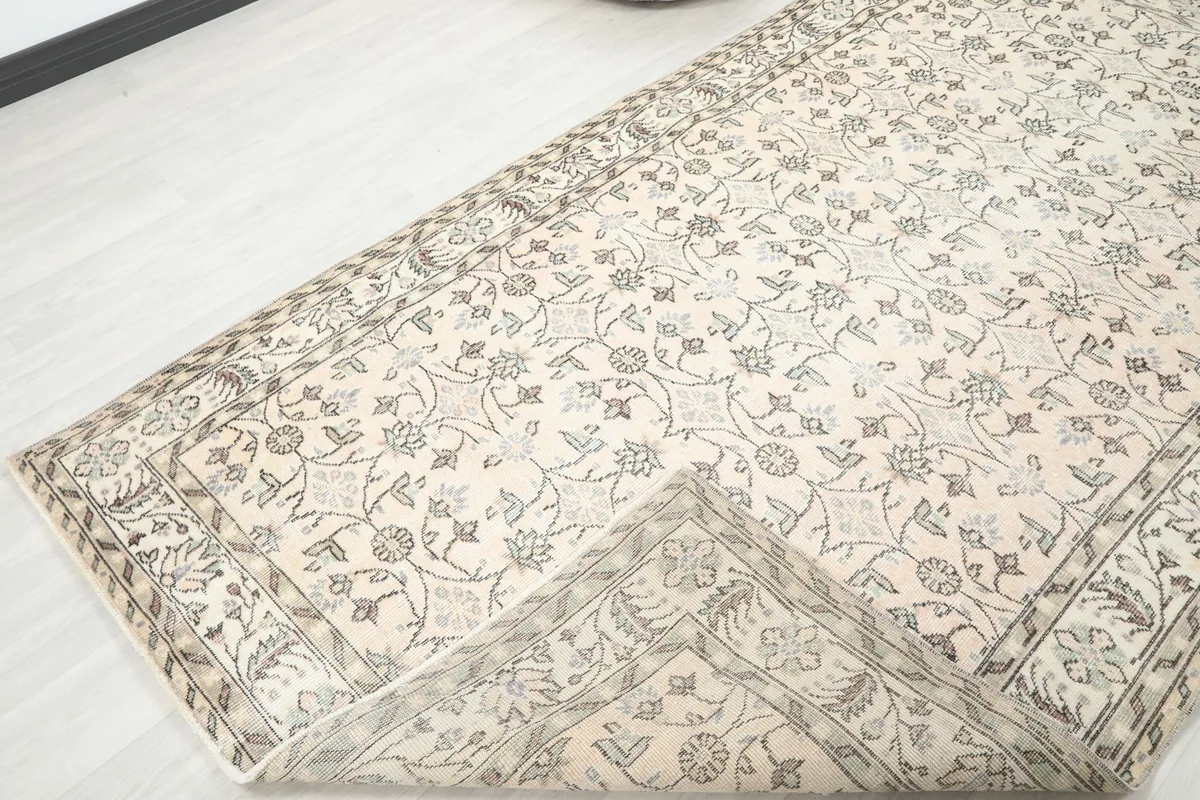 View of the rug folded back, showcasing the reverse side and knotting.
