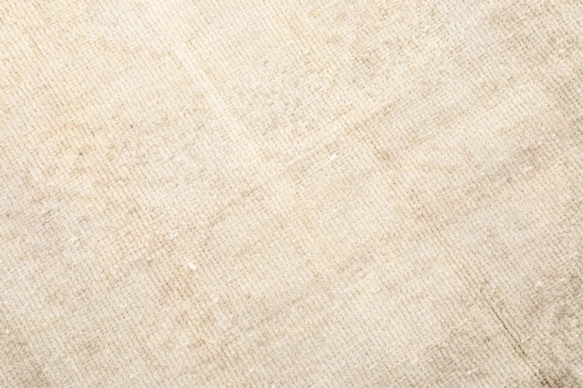 Close-up of the low wool pile, showing the hand-knotted texture and gentle wear of the vintage rug.