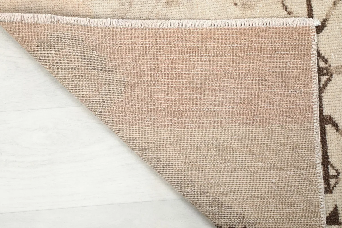 View of the rug's cotton foundation from the back, indicating its hand-knotted construction.