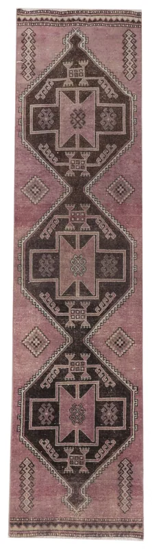 Full overhead view of a vintage rose and brown geometric tribal runner rug
