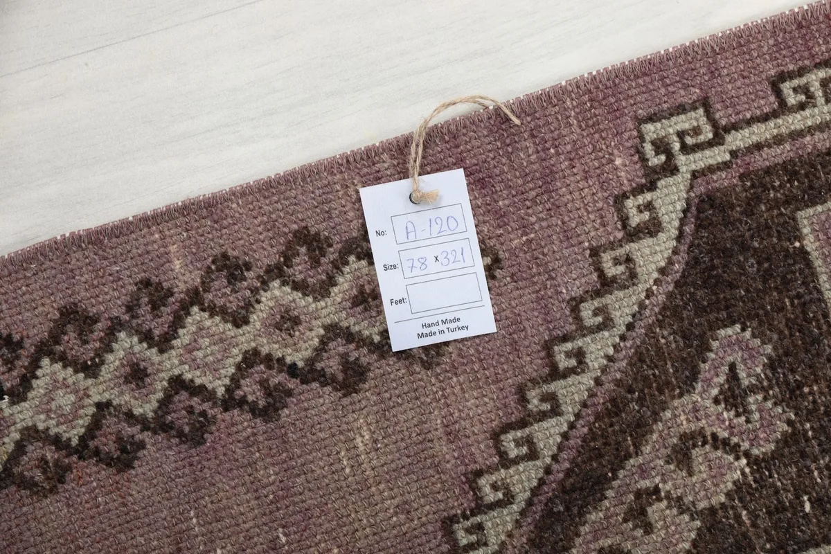 Detail of the rug's surface with an information tag displaying size and origin