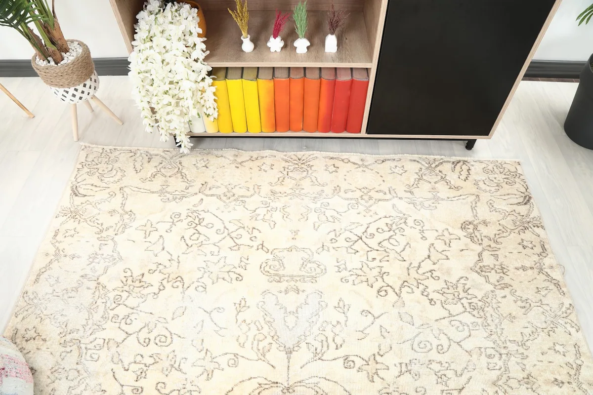 View of the upper section of the ivory and charcoal vintage rug, highlighting the distressed floral motifs