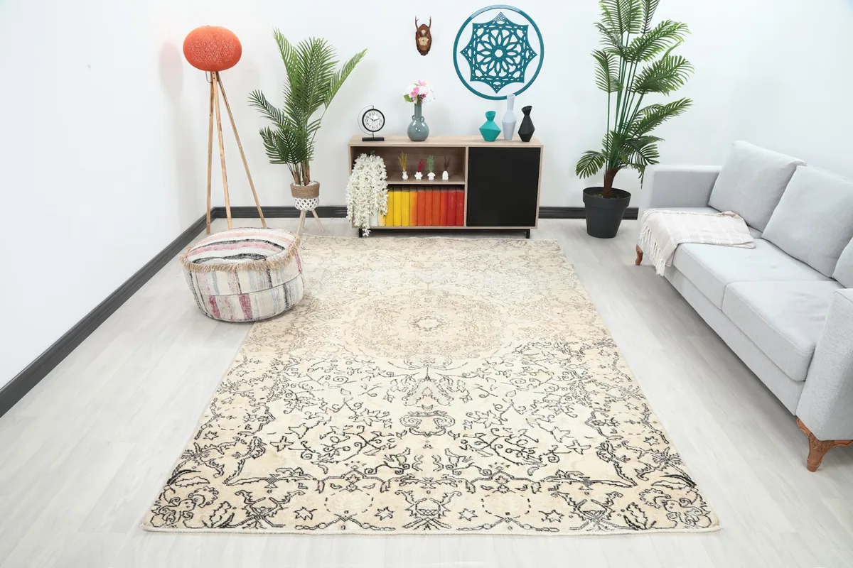 Ivory and charcoal vintage rug displayed in a modern living room setting with a light gray sofa