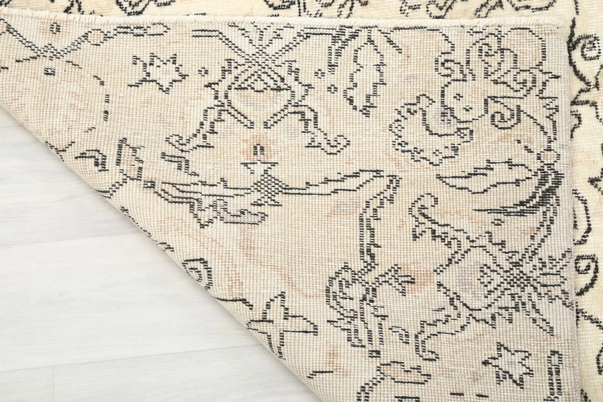 Close-up of the back of the ivory vintage rug, revealing the cotton foundation and hand-knotted construction
