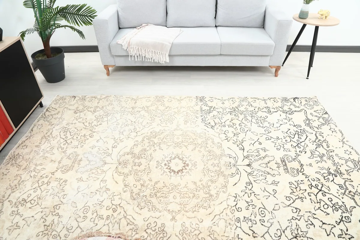 Overhead view of the ivory and charcoal vintage rug in a room, showing its full design and colors