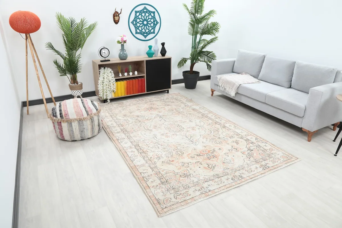 Overhead view of the ivory and orange floral rug in a room with light flooring