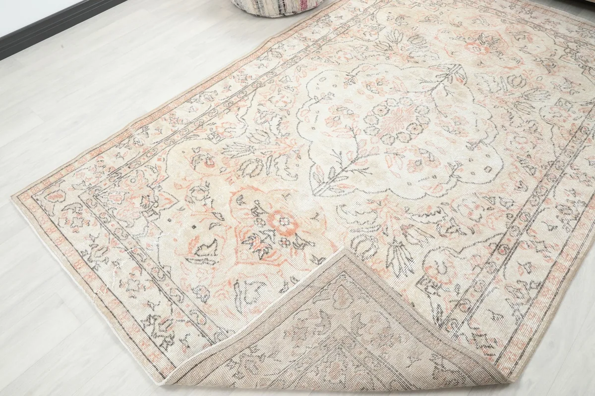 Corner of the rug folded back to show the cotton foundation and hand-knotted construction