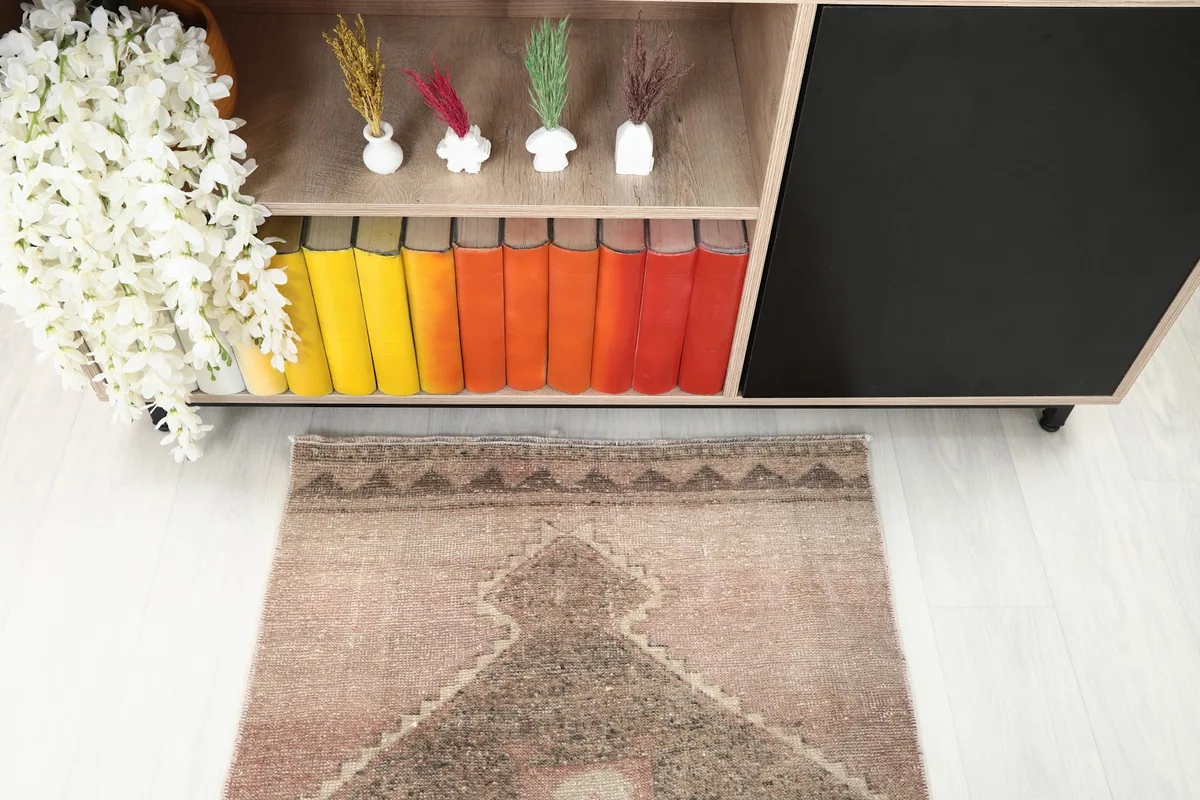 View of the runner's end near a wooden cabinet with colorful books, showing border details