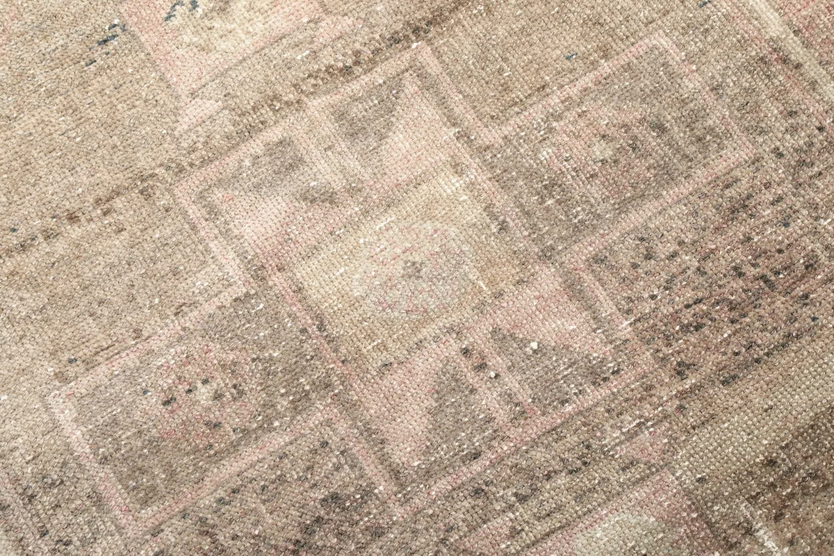 Macro detail of the hand-knotted wool pile, showing the intricate geometric patterns and color variations