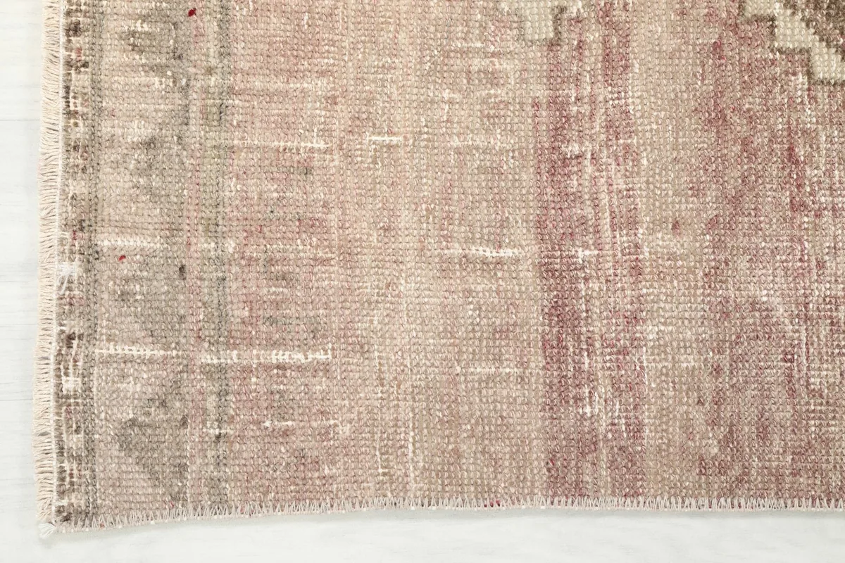 Edge detail of the vintage runner, revealing the subtle border design and color fading