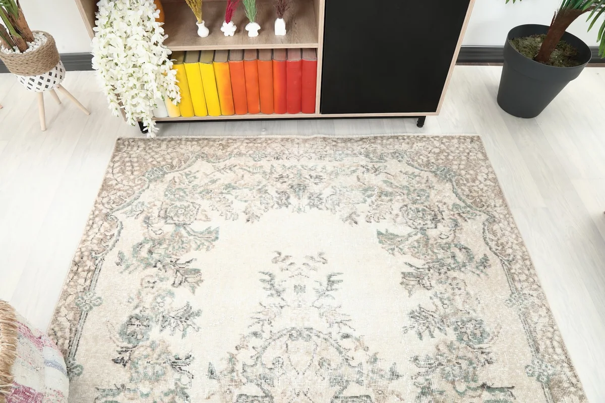 Angled view of the rug's top portion, highlighting the ivory field and faded designs