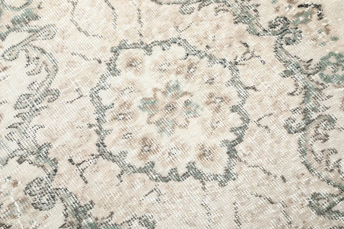 Close-up of the intricate floral detail within the medallion, showing natural wear