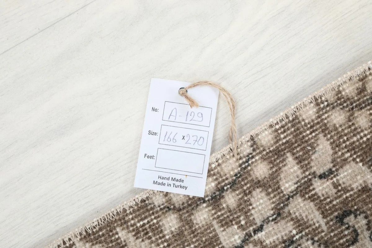 Product tag with rug dimensions 166 x 270 cm, indicating it is hand-made in Turkey