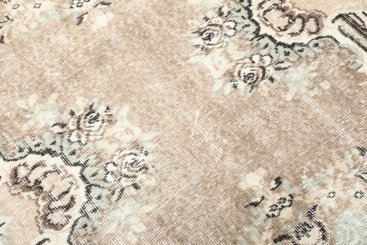 Close-up of the low wool pile, showing the texture and subtle color blending of the vintage rug.