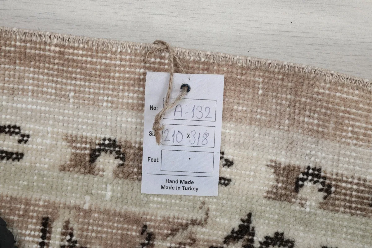 Tag showing the rug's dimensions (210 x 318 cm) and origin (Hand Made in Turkey).
