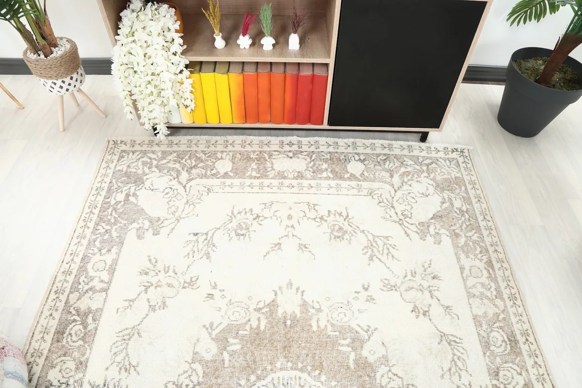 Top-down view of the rug's upper section, highlighting the ivory and beige border and field