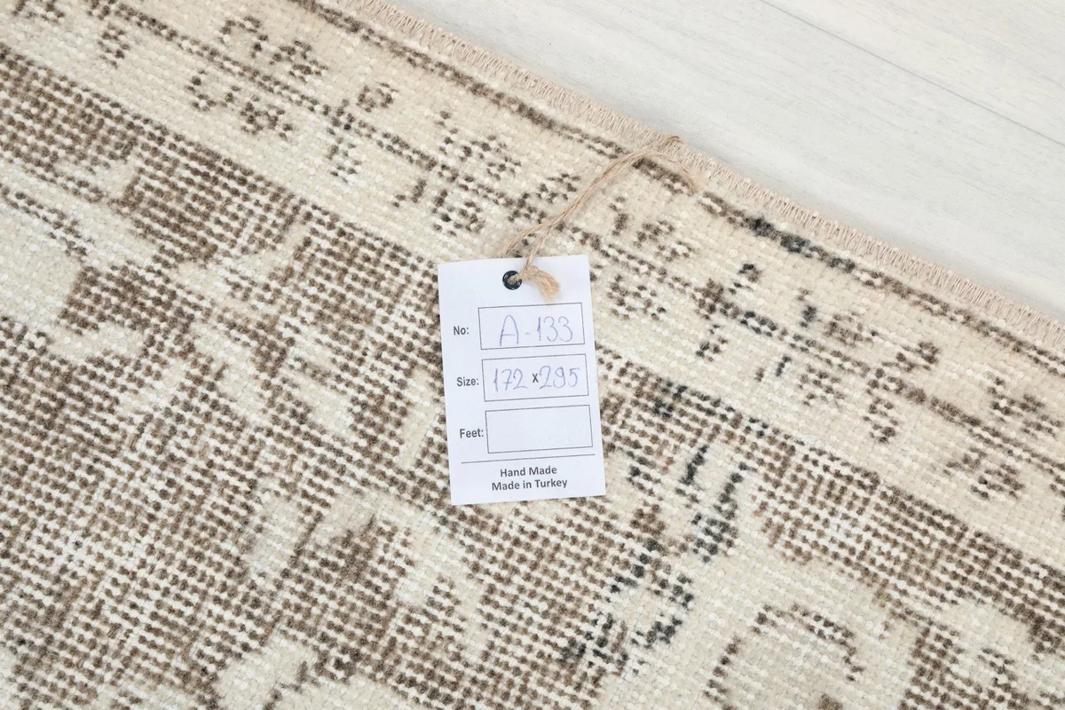 Label attached to the rug's corner, indicating its size and handmade origin in Turkey