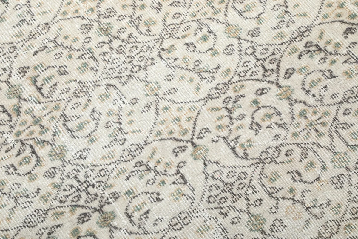 Close-up of the vintage wool pile showing olive and gray motifs