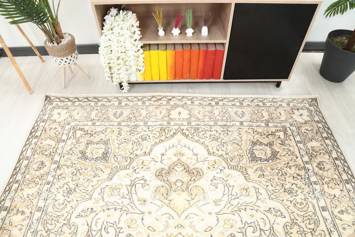 Detail view of the rug's border and part of the central field, showing its muted colors and patterns.