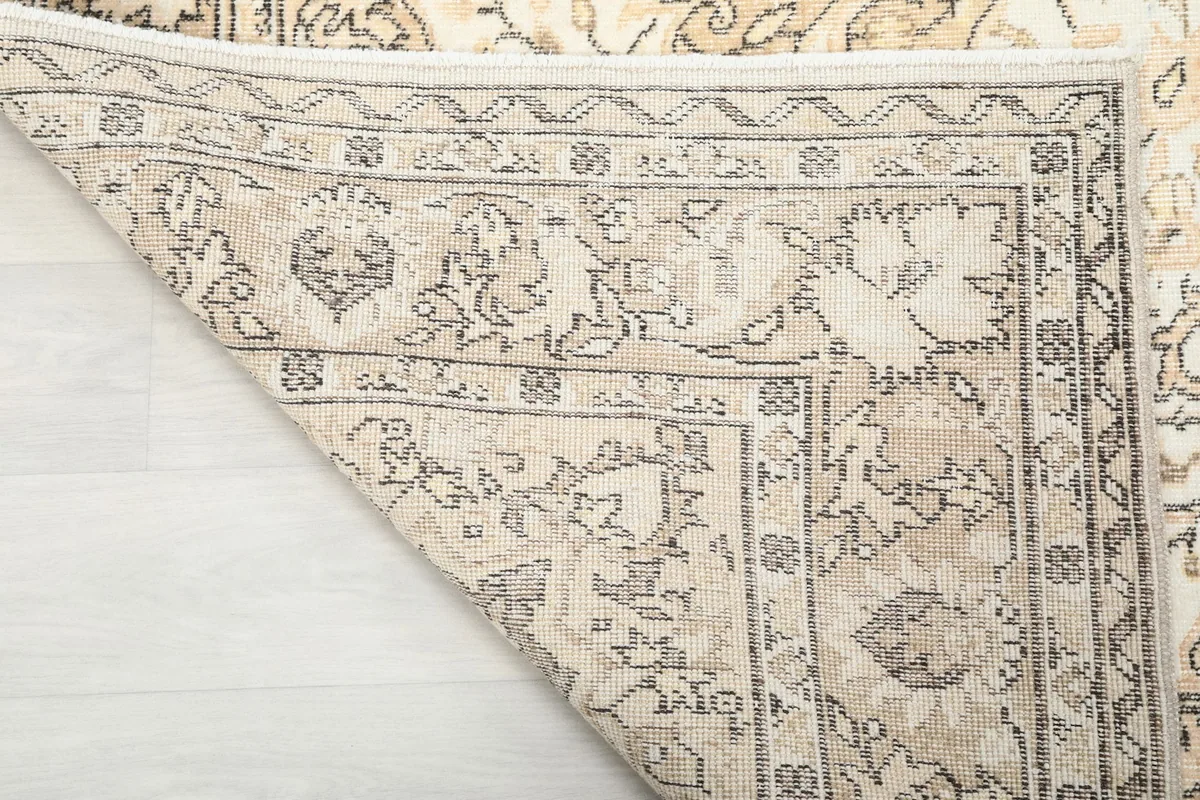 Close-up of the hand-knotted cotton foundation visible from the underside of the vintage rug.