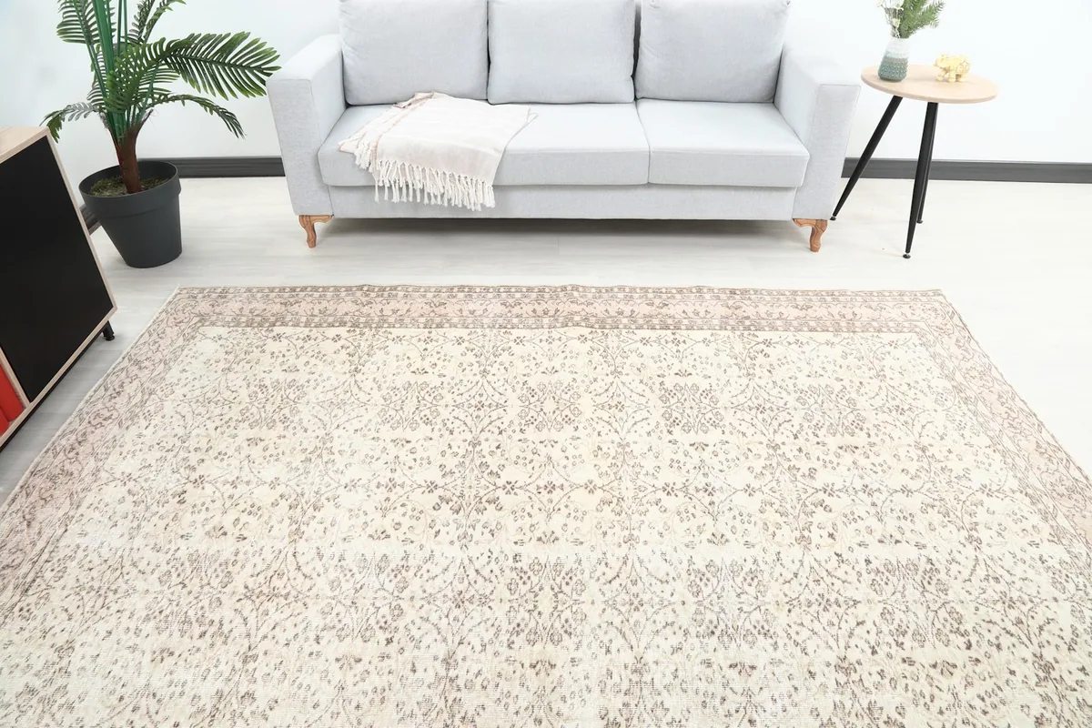 View of the ivory and rose rug in a room with a light gray sofa