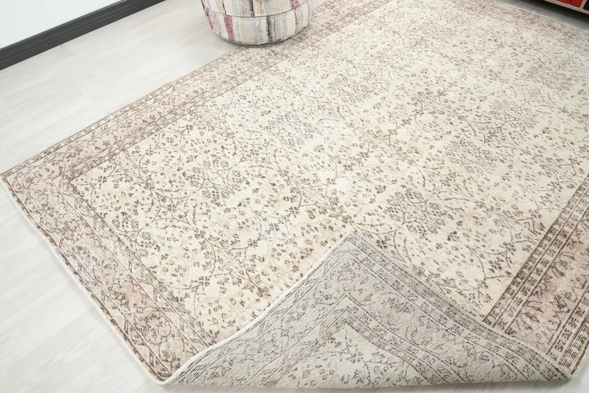 Corner of the vintage Anatolian rug lifted to show the back and cotton foundation