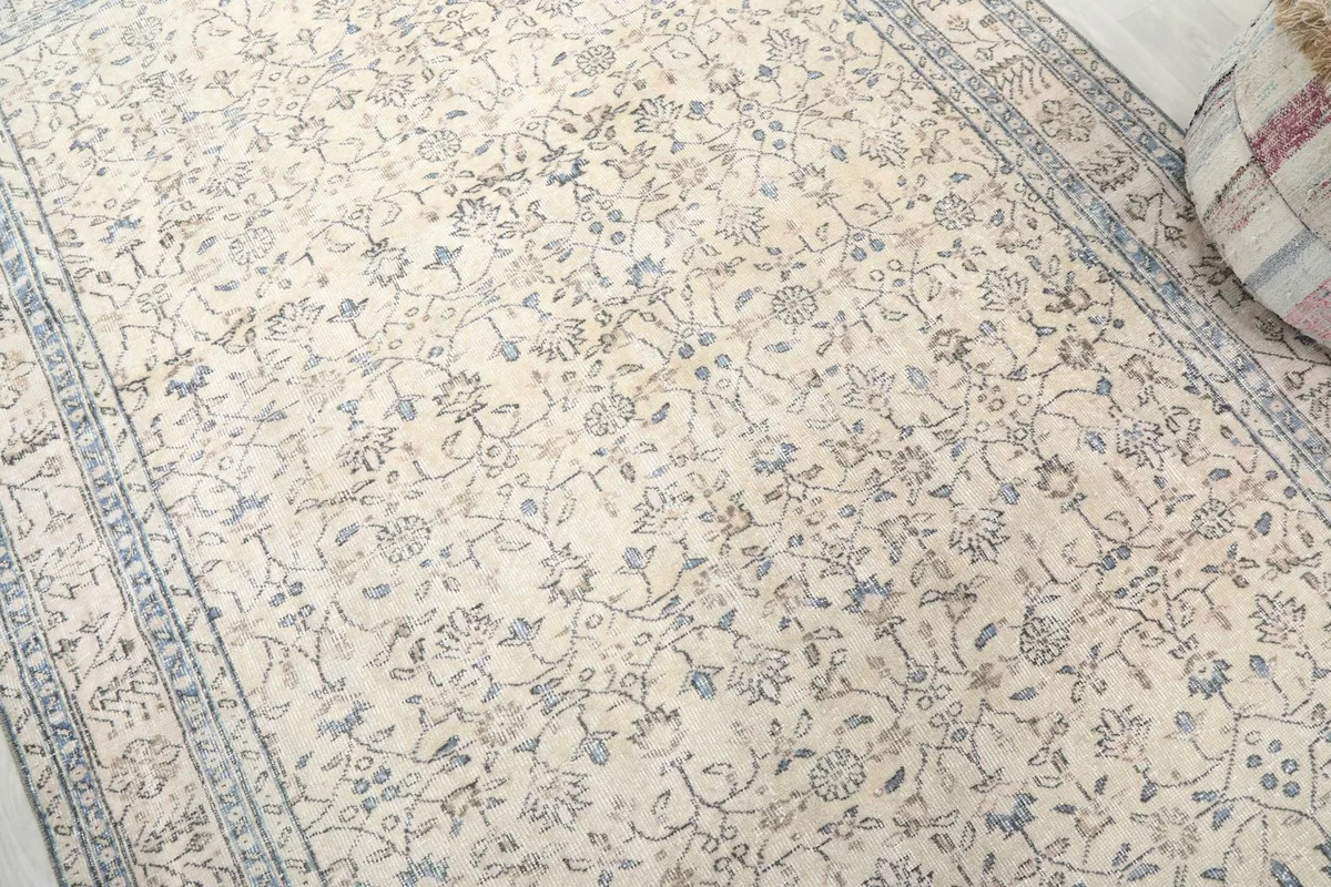 Detailed angle shot highlighting the ivory field and blue floral patterns on the rug