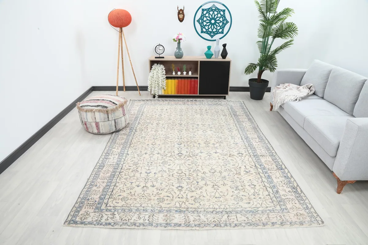 Ivory and blue vintage rug in a modern living room setting with a gray sofa