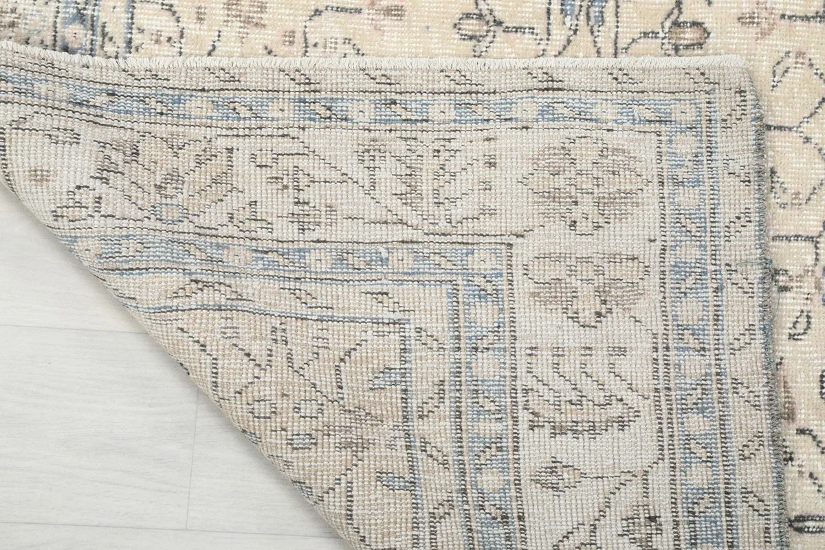 Close-up of the rug's reverse side and corner, showing the cotton foundation and knotting