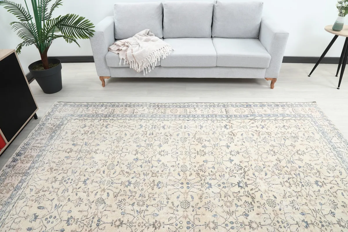 Overhead view of the ivory and blue rug in a room, showing the full design