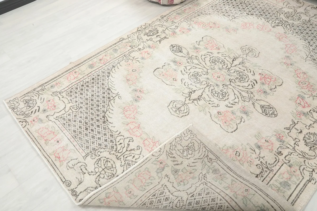View of the rug partially folded, revealing the underside and the hand-knotted construction