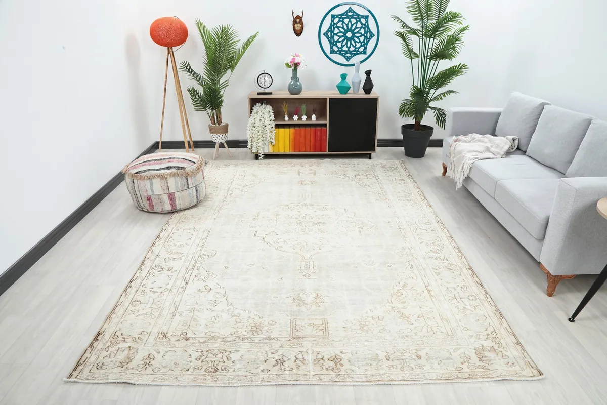Ivory and beige vintage rug in a living room setting, showing its scale and color in context