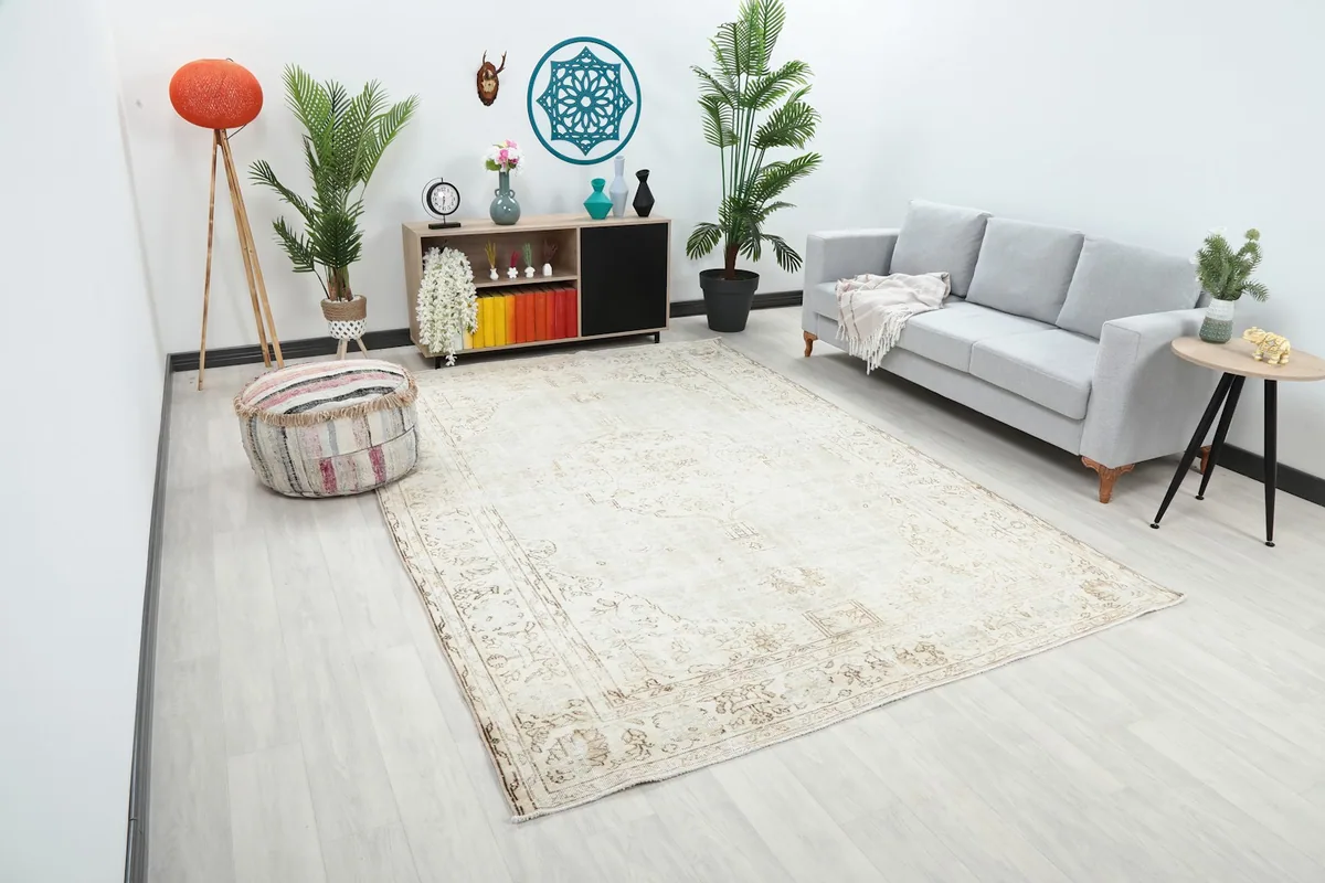 Angle view of the large vintage Anatolian rug in a contemporary living space with a gray sofa