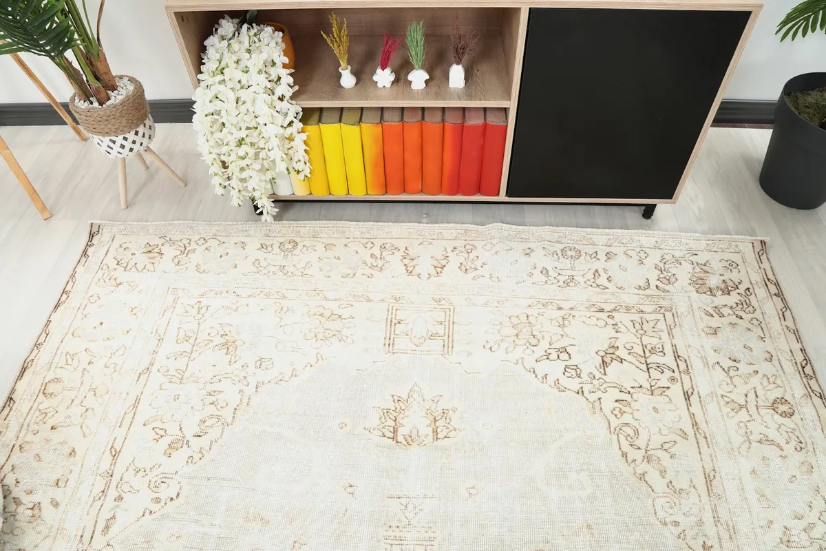 Overhead view focusing on the upper half of the rug, showing faded floral and geometric details