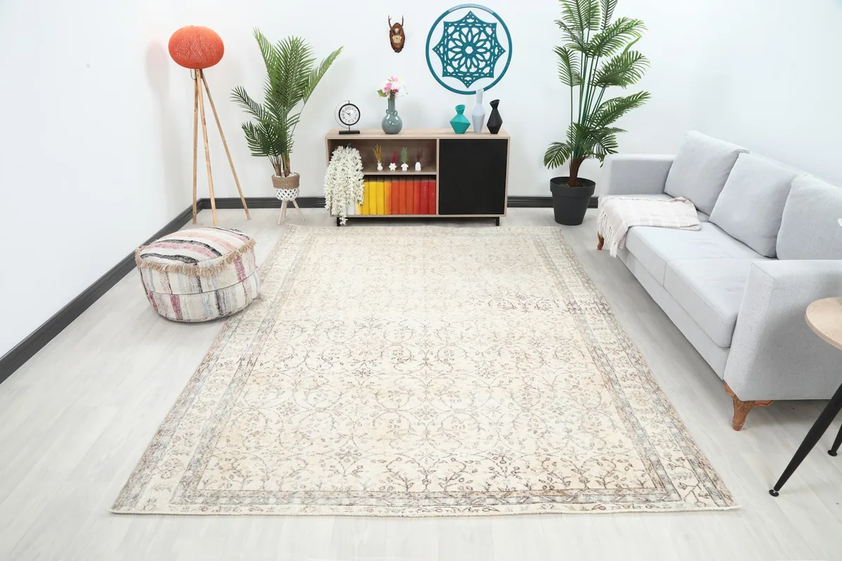 Ivory vintage Anatolian rug displayed in a living room setting with a light gray sofa and modern decor.