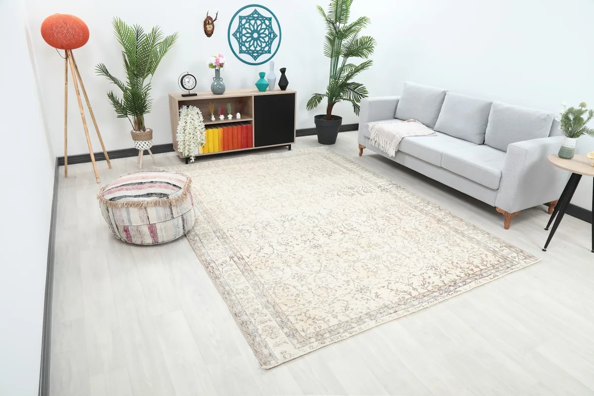 View of the ivory floral rug in a spacious room, showcasing its medium size and subtle pattern.